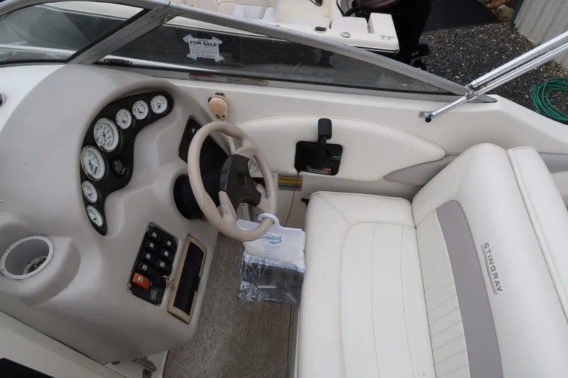 Slide: The Image of 2004 Stingray 240 CS boat interior with steering wheel and dashboard controls. - 13