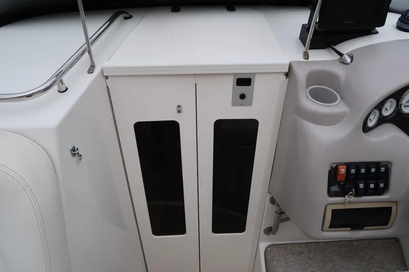 Slide: The Image of 2004 Stingray 240 CS boat interior with control panel and storage compartments. - 21