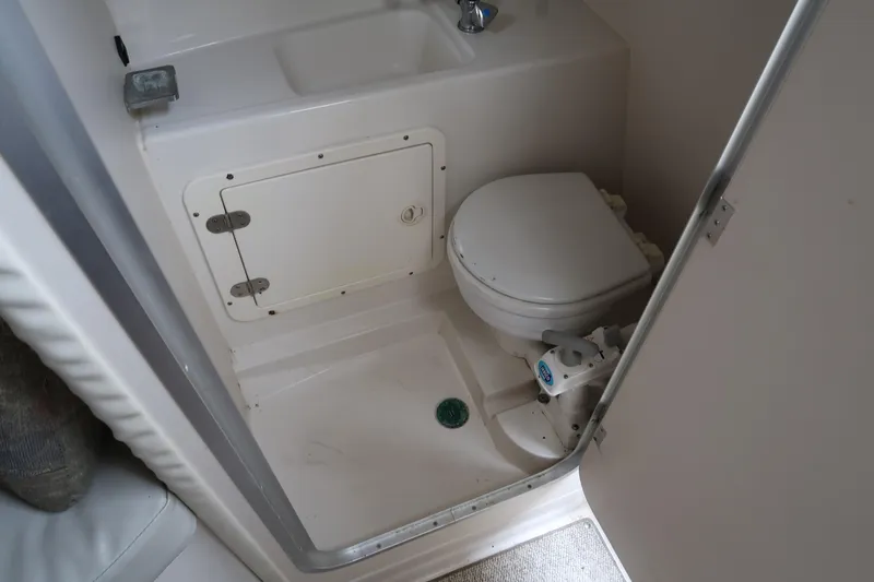 Slide: The Image of 2004 Stingray 240 CS boat bathroom with toilet and sink. - 28
