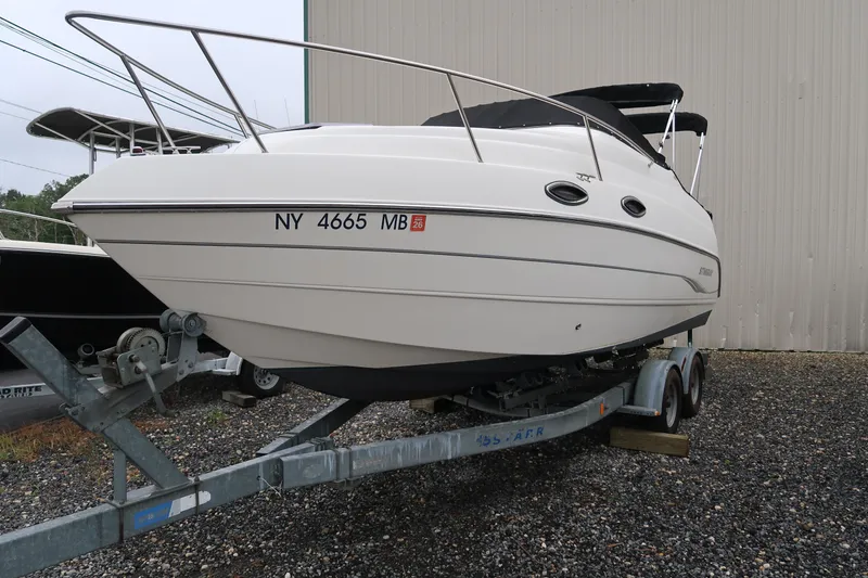Slide: The Image of 2004 Stingray 240 CS boat on trailer, parked outdoors. - 4