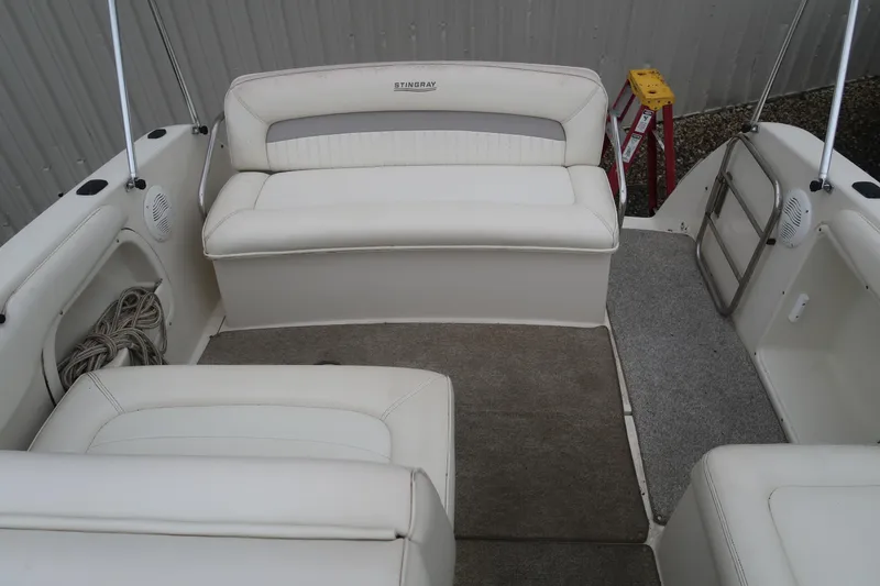 Slide: The Image of 2004 Stingray 240 CS boat interior with white seating and carpeted floor. - 7