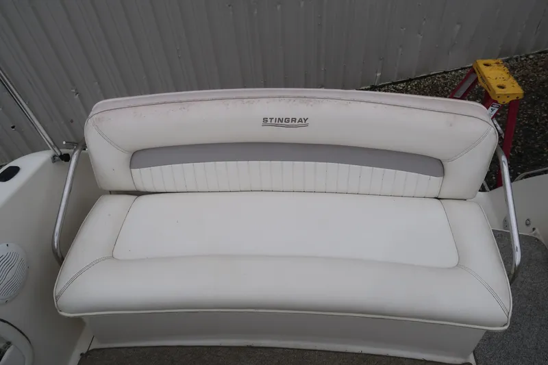 Slide: The Image of 2004 Stingray 240 CS boat seat with white upholstery and gray accents. - 9