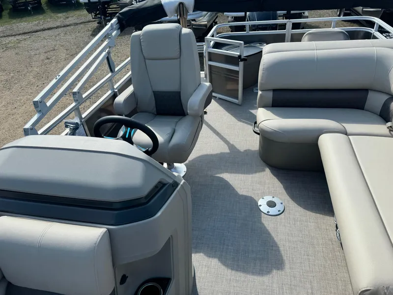 Slide: The Image of 2025 Sun Tracker Fishin' Barge 20 DLX interior with seating and steering wheel. - 12