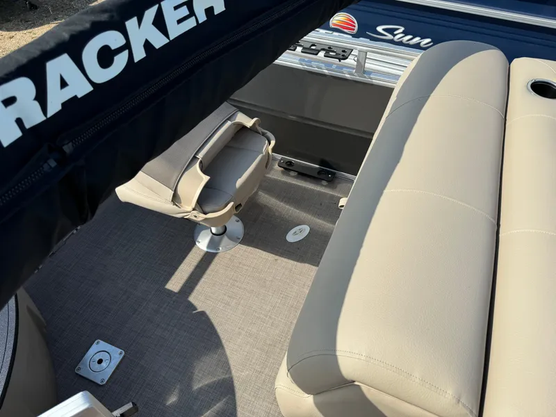 Slide: The Image of 2025 Sun Tracker Fishin' Barge 20 DLX interior with beige seating and fishing chair. - 18