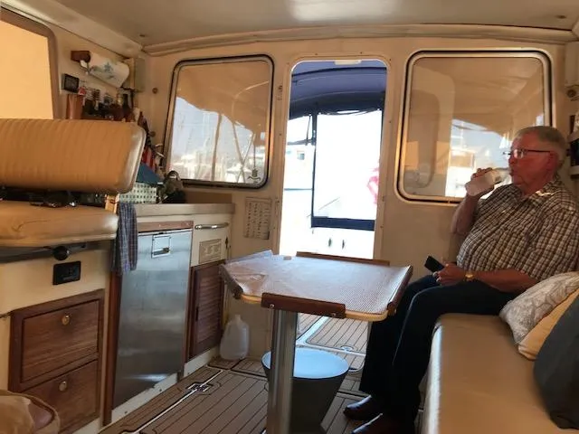 Slide: The Image of Interior of a 2004 Atlas Boat Works Acadia 32 with a seated man. - 10