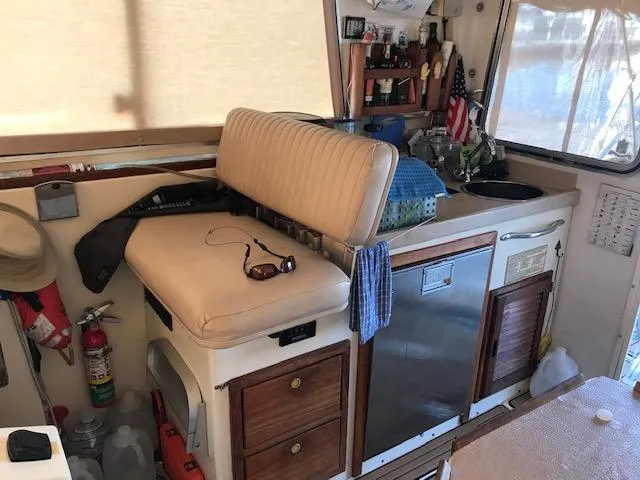 Slide: The Image of Interior of a 2004 Atlas Boat Works Acadia 32, featuring seating and kitchenette. - 11