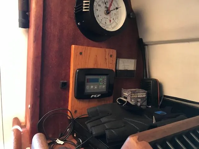 Slide: The Image of Interior of Atlas Boat Works Acadia 32, 2004, featuring control panel and clock. - 9