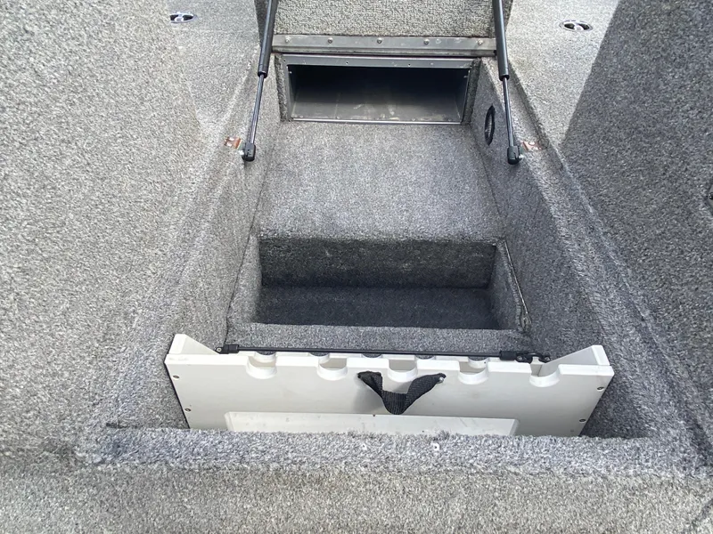 Slide: The Image of 2007 Lund 1900 Pro V SE boat storage compartment, open and carpeted. - 24