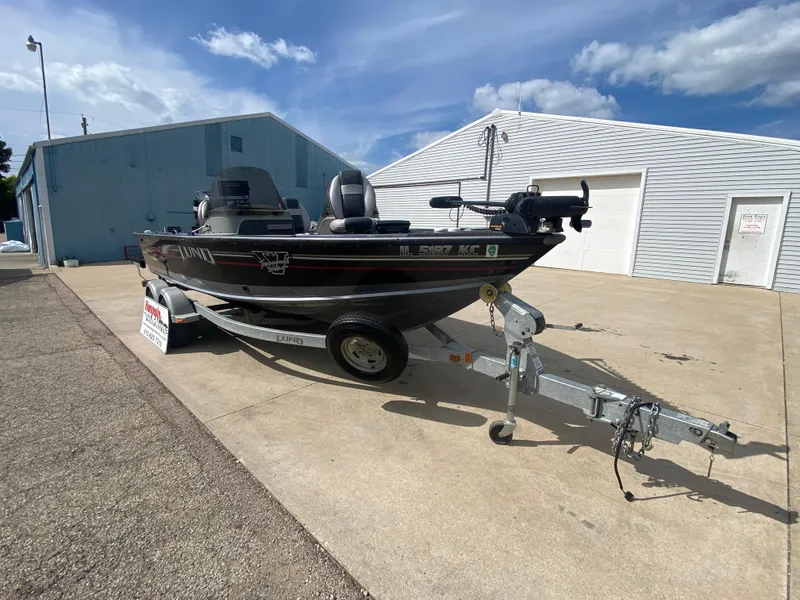 Slide: The Image of 2007 Lund 1900 Pro V SE boat on trailer, parked outside under blue sky. - 8