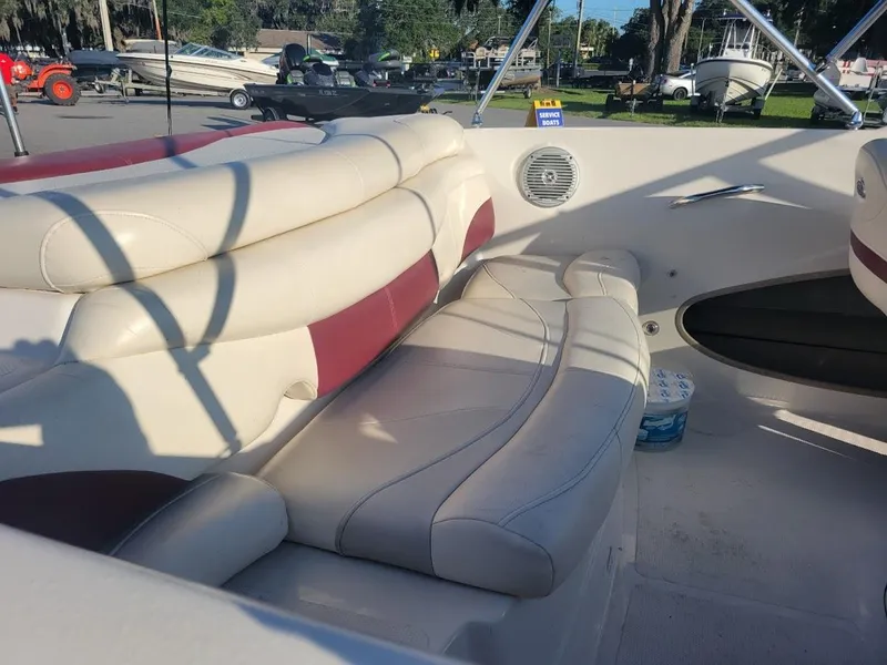 Slide: The Image of 2011 Tahoe Q5i boat interior with beige and red seating in sunlight. - 6