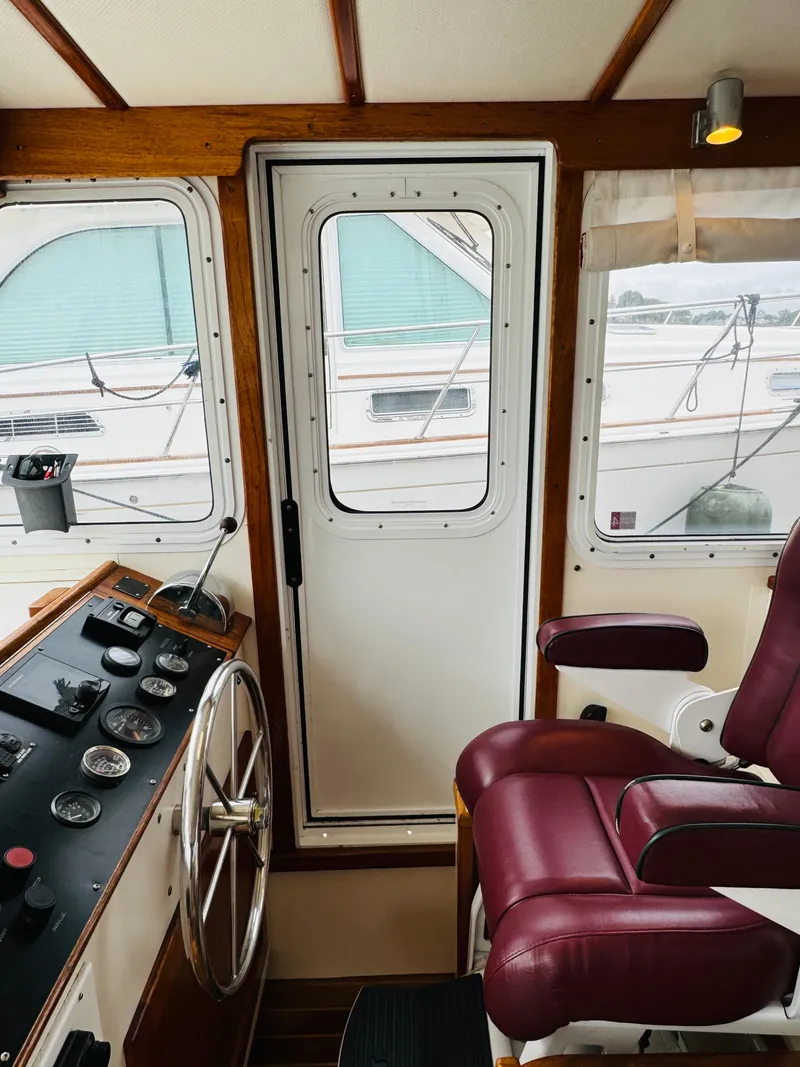 Slide: The Image of Interior of 2000 Holland 38 Downeast Cruiser with steering wheel and maroon captain's chair. - 14