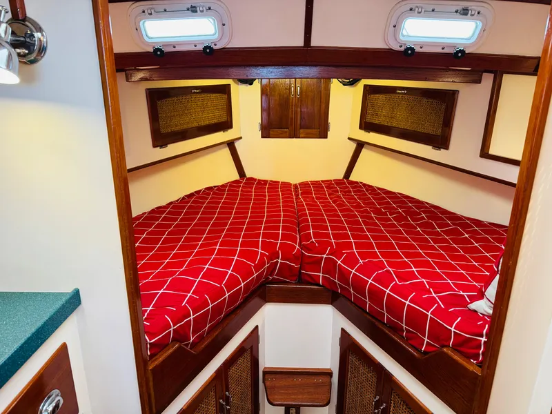 Slide: The Image of Cozy cabin interior of 2000 Holland 38 Downeast Cruiser with red checkered bedding. - 17