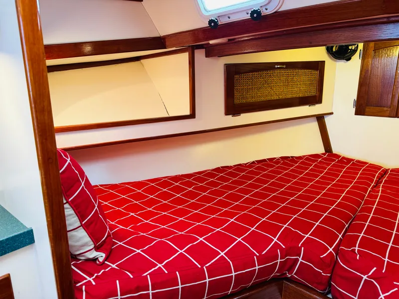 Slide: The Image of Cozy cabin interior of 2000 Holland 38 Downeast Cruiser with red checkered bedding. - 18
