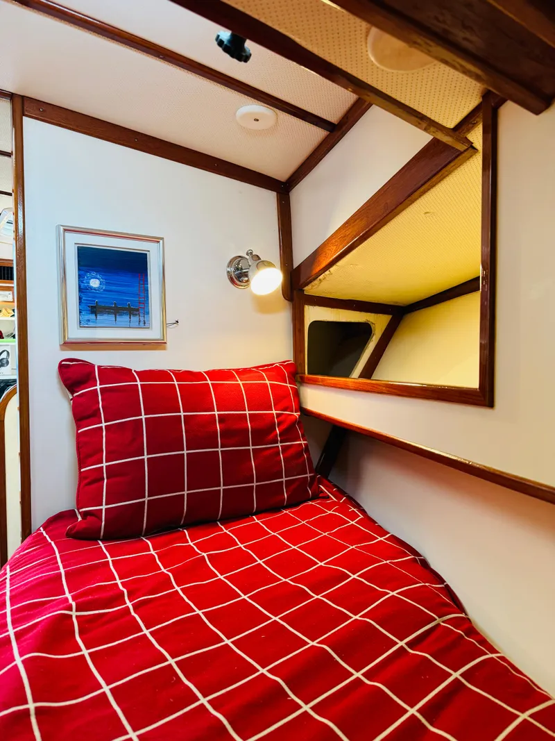 Slide: The Image of Cozy cabin interior of 2000 Holland 38 Downeast Cruiser with red checkered bedding. - 22