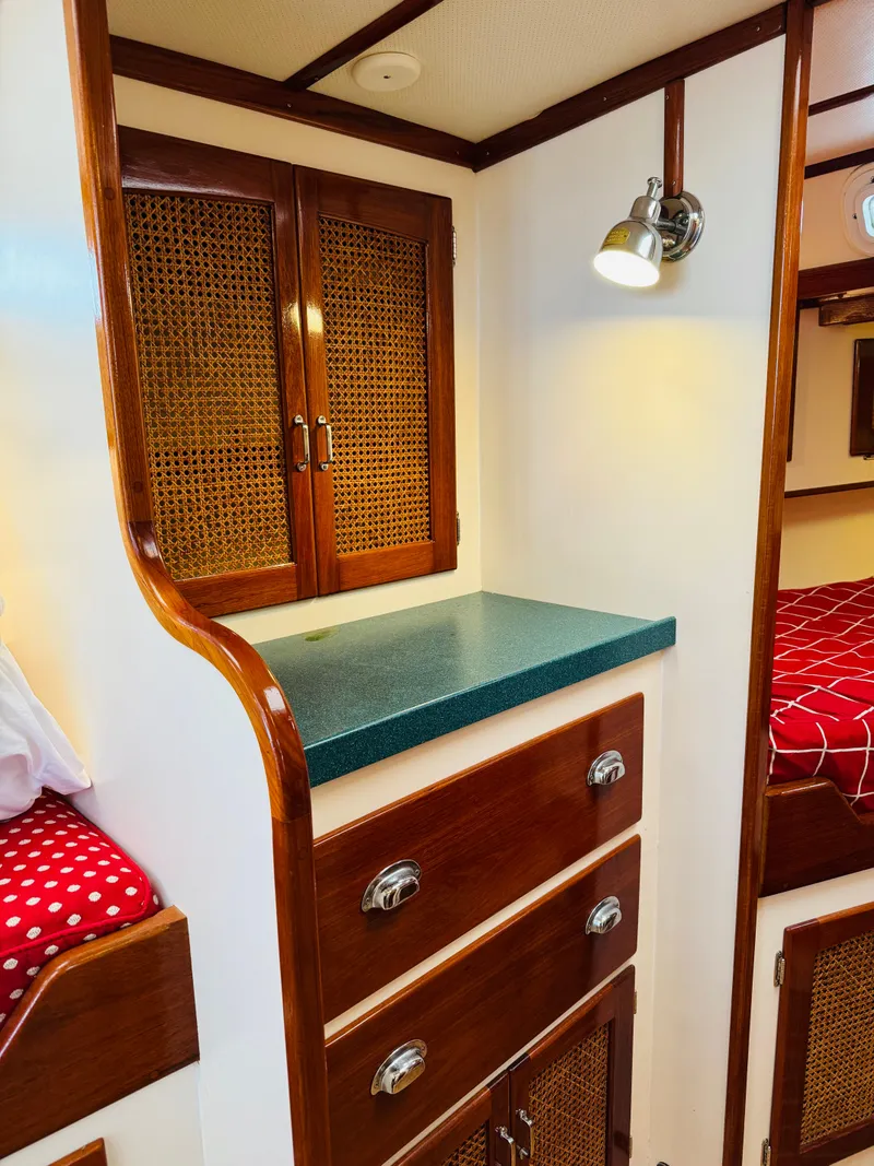 Slide: The Image of Interior of 2000 Holland 38 Downeast Cruiser with wooden cabinets and cozy bedding. - 30