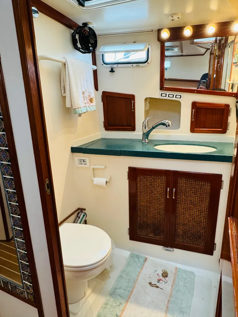 Slide: The Image of Bathroom interior of 2000 Holland 38 Downeast Cruiser with sink, toilet, and wooden accents. - 32