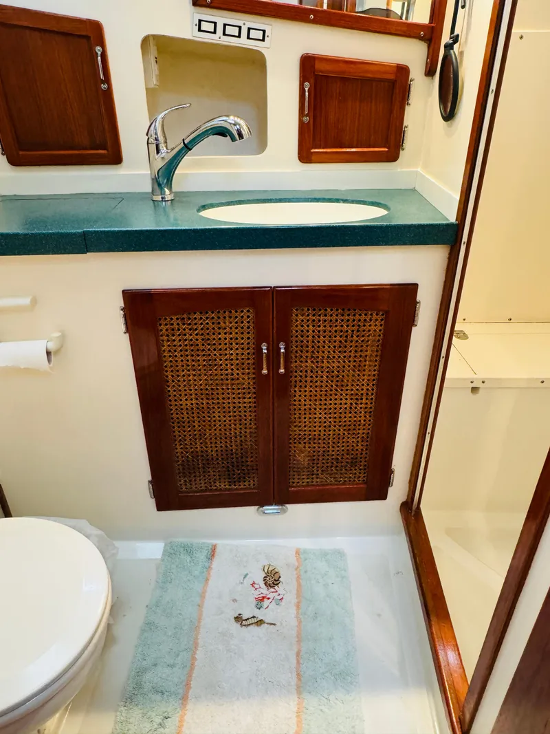 Slide: The Image of Bathroom interior of 2000 Holland 38 Downeast Cruiser with wooden cabinets and green countertop. - 33