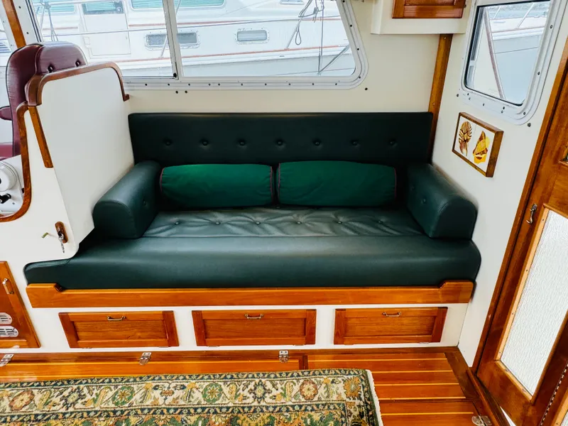 Slide: The Image of Interior of 2000 Holland 38 Downeast Cruiser with green leather seating and wooden accents. - 4