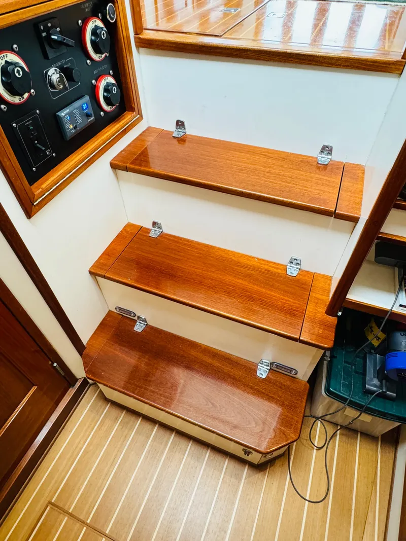 Slide: The Image of Wooden steps inside a 2000 Holland 38 Downeast Cruiser with control panel. - 40