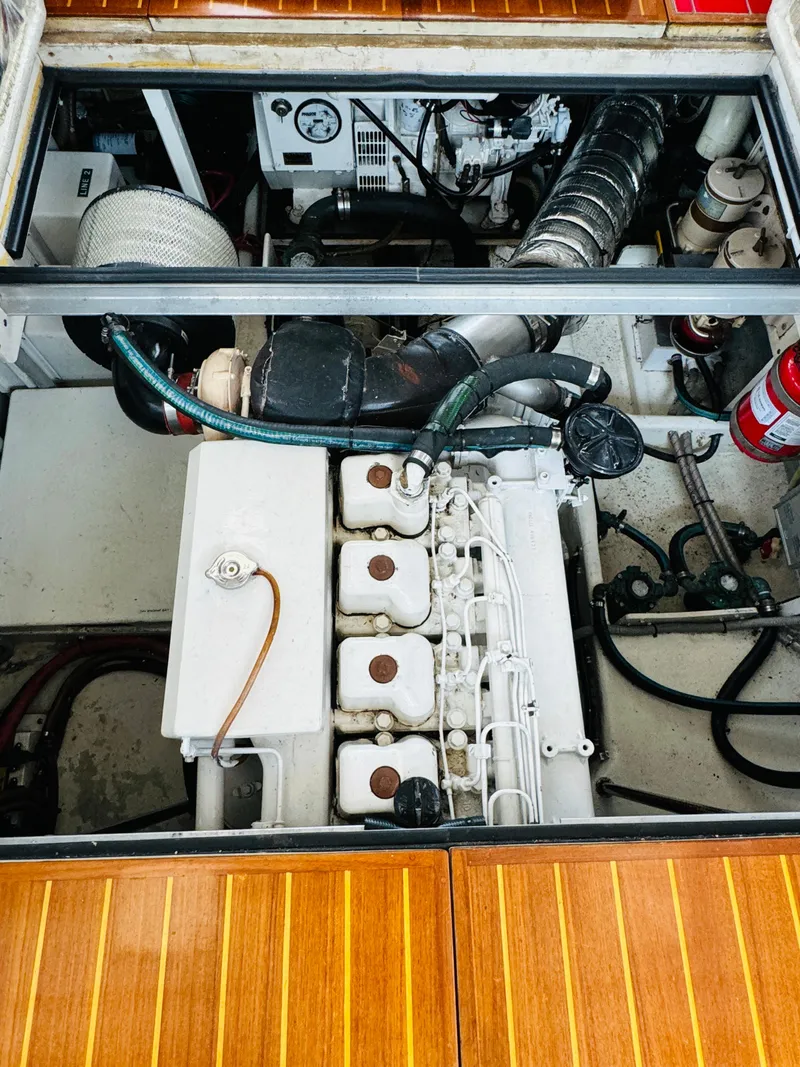 Slide: The Image of Engine compartment of 2000 Holland 38 Downeast Cruiser with visible components and wooden deck. - 44