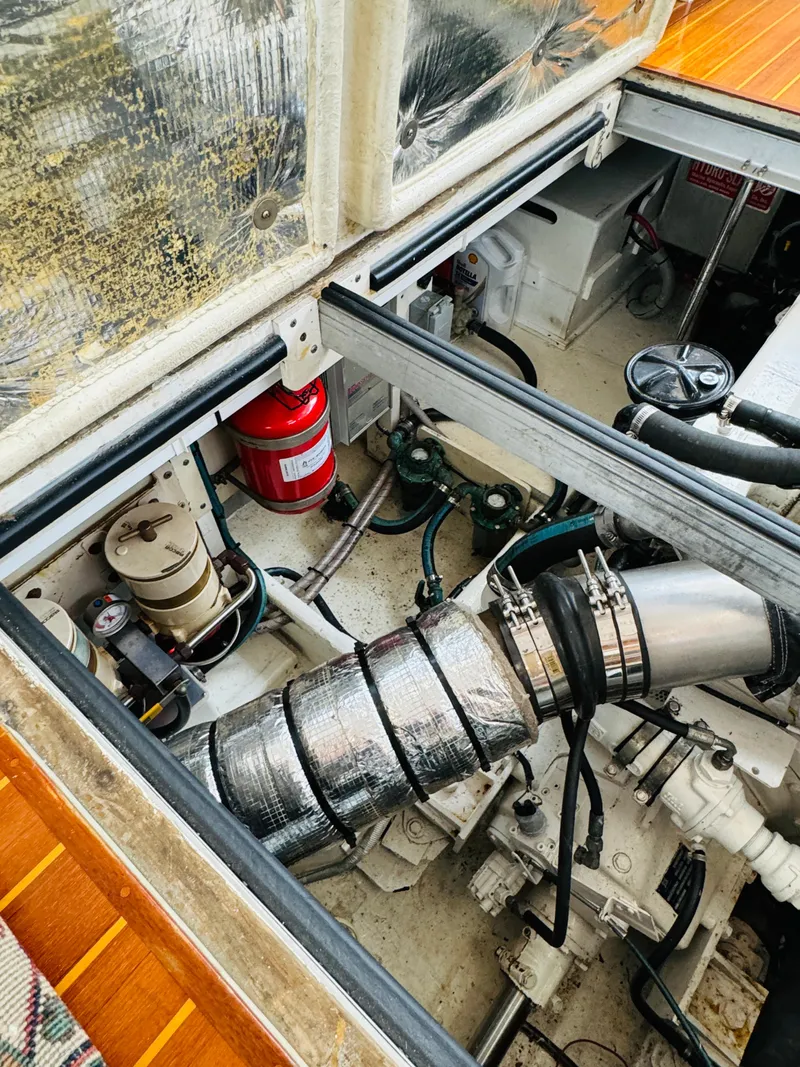 Slide: The Image of Engine compartment of 2000 Holland 38 Downeast Cruiser with visible components and fire extinguisher. - 49
