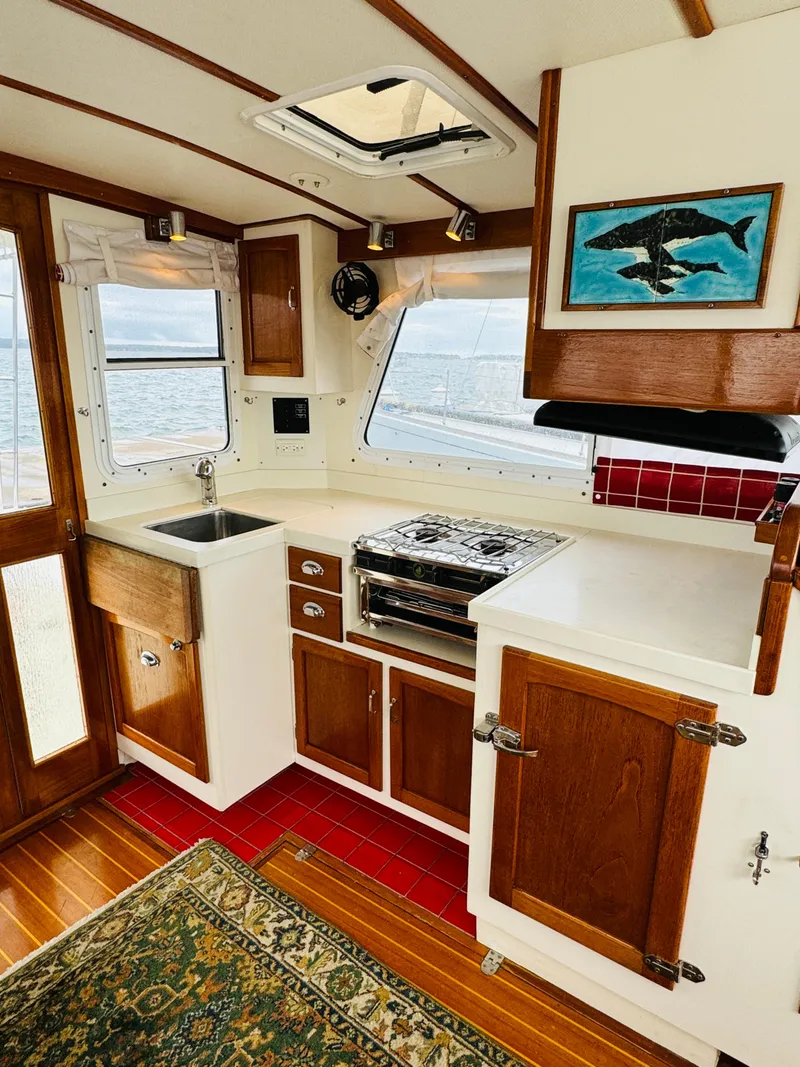 Slide: The Image of Interior of 2000 Holland 38 Downeast Cruiser with kitchen and wooden cabinetry. - 7