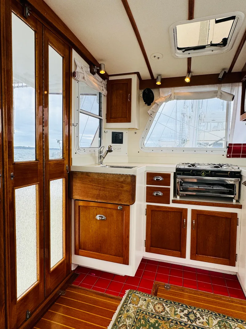 Slide: The Image of Interior of 2000 Holland 38 Downeast Cruiser with wooden cabinetry and nautical decor. - 9