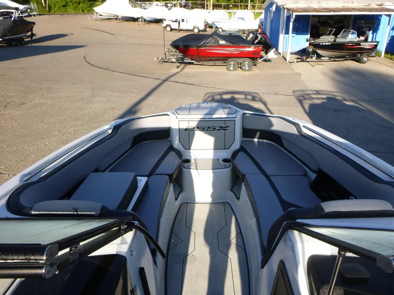 Slide: The Image of 2024 Yamaha Boats 255XE interior view at a marina with other boats. - 6