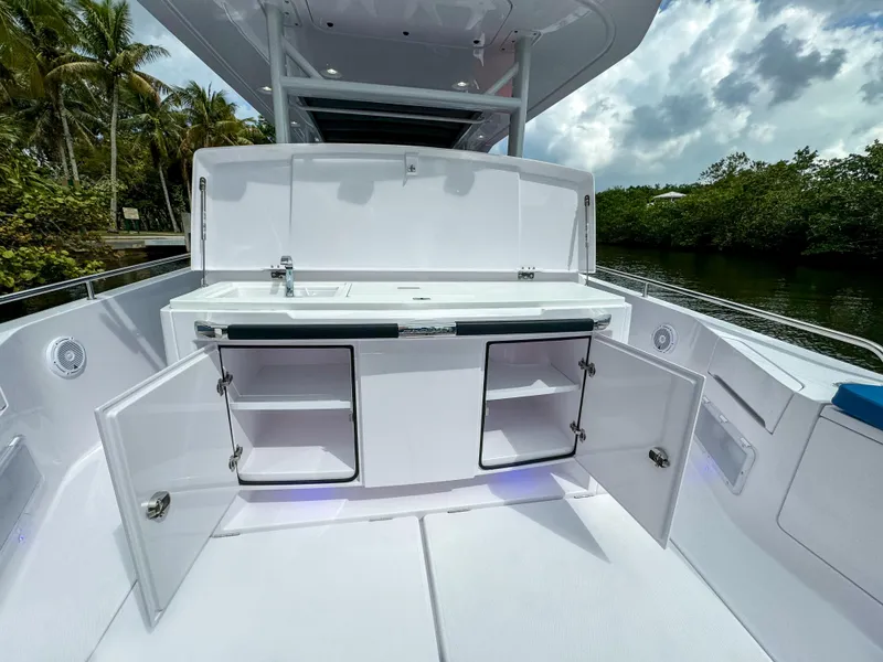 Slide: The Image of 2024 Axopar 37 Sun Top boat with open storage compartments and sleek design. - 8