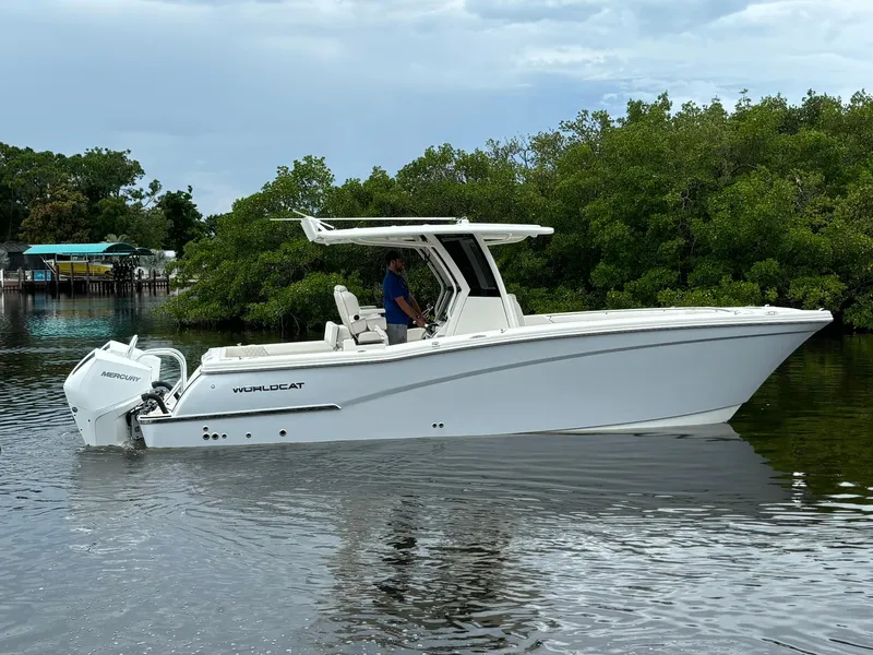 The Image of 2025 World Cat 280 CC-X boat on calm water, surrounded by lush greenery. - 0