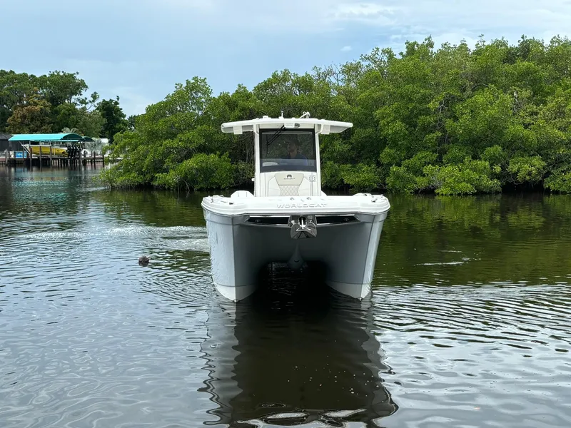 Slide: The Image of 2025 World Cat 280 CC-X boat on calm water near lush greenery. - 1