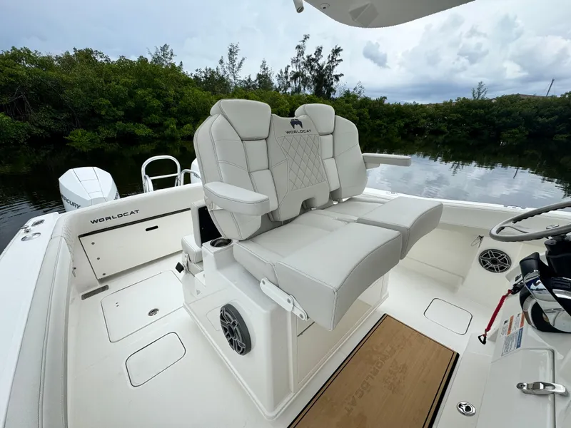 Slide: The Image of 2025 World Cat 280 CC-X boat interior with plush seating and scenic water backdrop. - 14