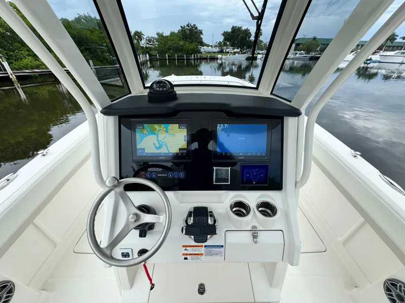 Slide: The Image of 2025 World Cat 280 CC-X boat dashboard with dual screens and steering wheel. - 17
