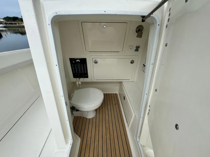 Slide: The Image of 2025 World Cat 280 CC-X boat interior with compact bathroom and wooden flooring. - 18
