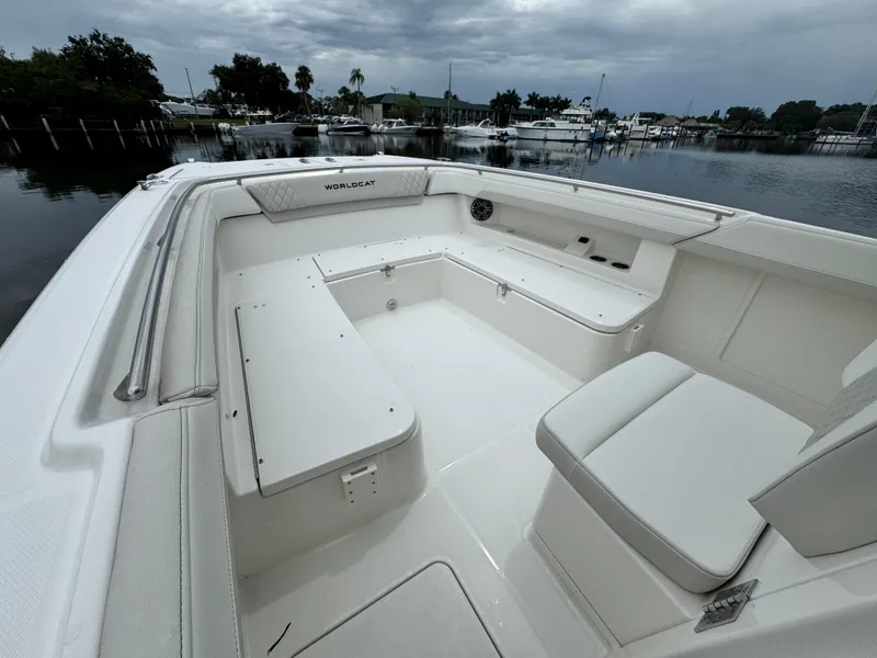 Slide: The Image of 2025 World Cat 280 CC-X boat interior with spacious seating, docked by a serene waterfront. - 19