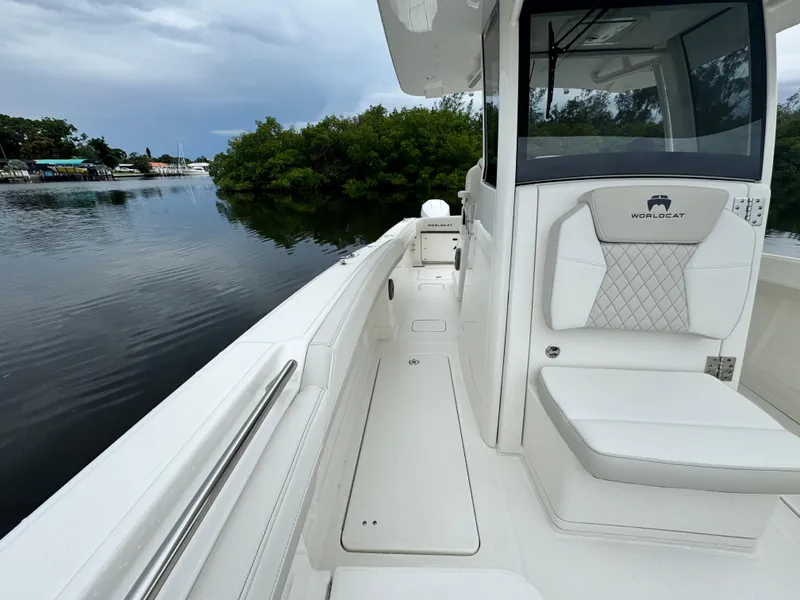Slide: The Image of 2025 World Cat 280 CC-X boat on calm water, featuring sleek white seating and modern design. - 22