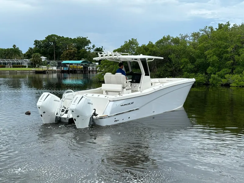 Slide: The Image of 2025 World Cat 280 CC-X boat cruising on a calm river near lush greenery. - 5