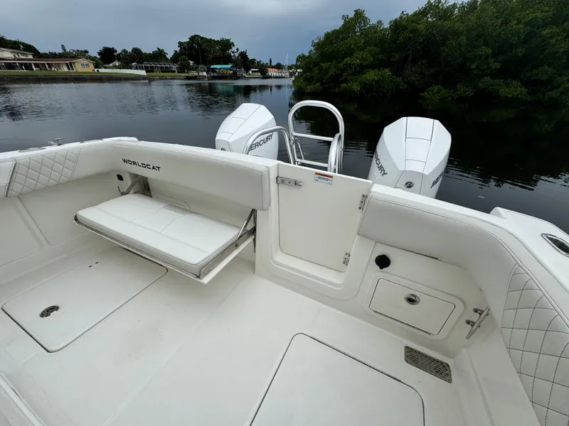 Slide: The Image of 2025 World Cat 280 CC-X boat interior with seating and dual engines on a calm waterway. - 9
