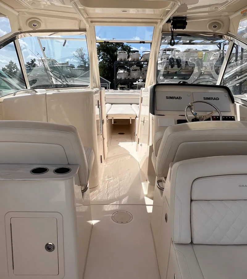 Slide: The Image of 2018 Grady-White Freedom 325 boat interior with dual Simrad displays and plush seating. - 2