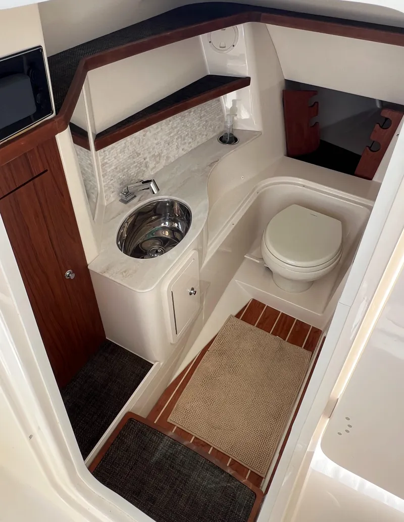 Slide: The Image of 2018 Grady-White Freedom 325 boat bathroom with sink, toilet, and wooden accents. - 6