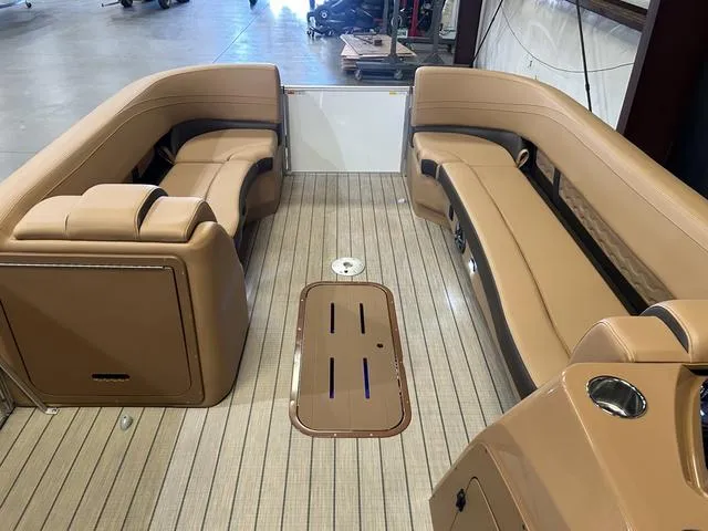 Slide: The Image of Luxurious interior of 2025 SunCatcher Fusion 322C boat with tan seating and wood flooring. - 9