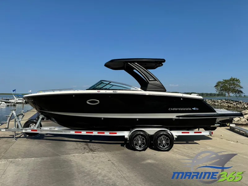 The Image of 2025 Chaparral 287 SSX boat on trailer by waterfront, clear sky background. - 0