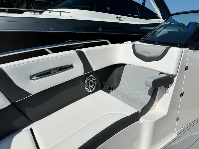 Slide: The Image of 2025 Chaparral 287 SSX boat interior with sleek white and black seating design. - 19
