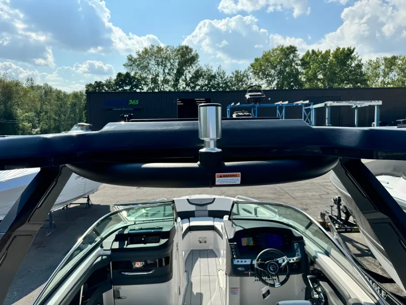 Slide: The Image of 2025 Chaparral 287 SSX boat interior with steering wheel, under a sunny sky. - 24
