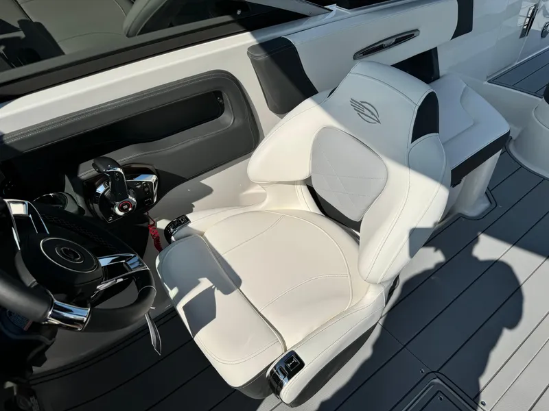 Slide: The Image of 2025 Chaparral 287 SSX boat interior with sleek white captain's seat and modern steering controls. - 47