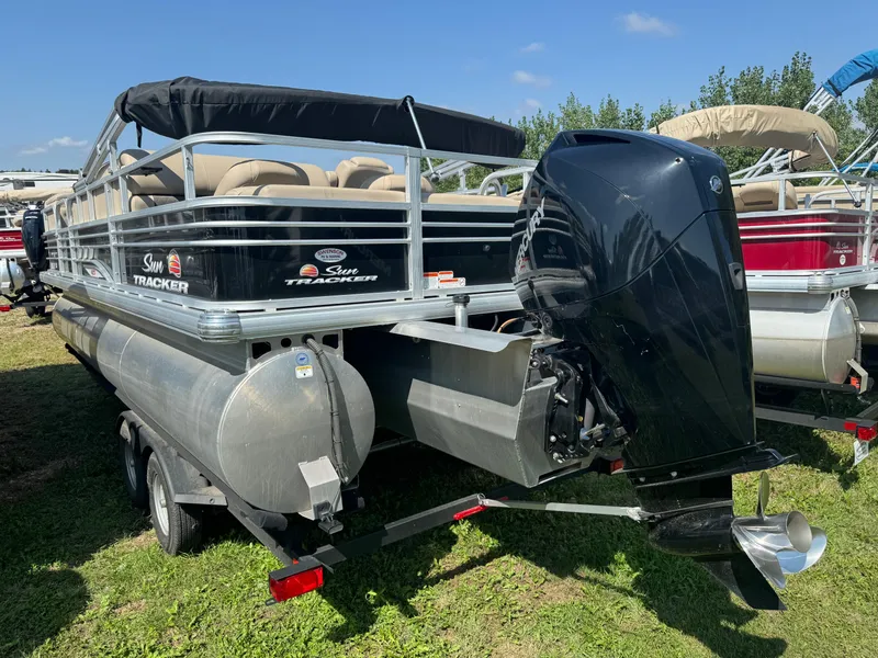 Slide: The Image of 2022 Sun Tracker SportFish 22 XP3 pontoon boat with outboard motor, parked on grass. - 5