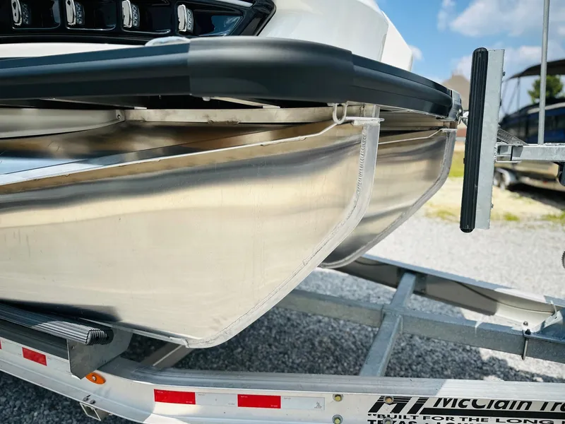 Slide: The Image of 2025 Harris Grand Mariner 250 pontoon boat on trailer, close-up view. - 11