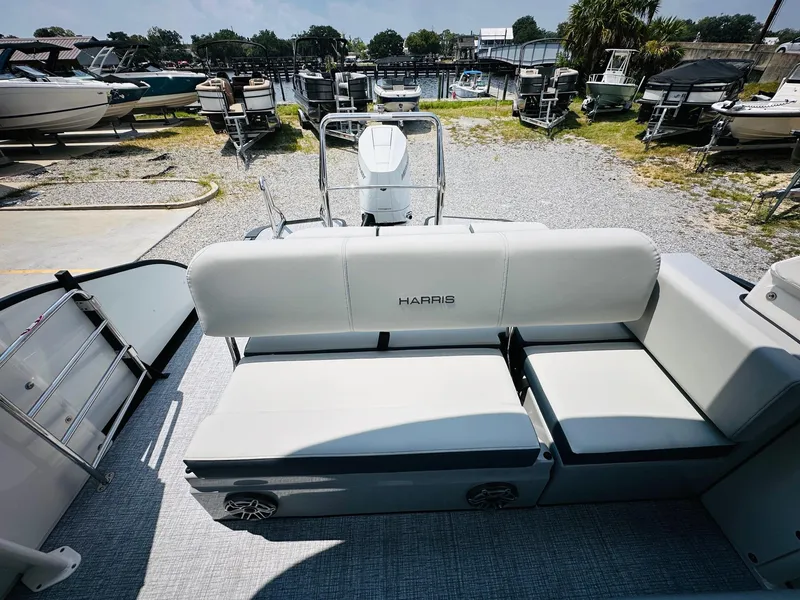 Slide: The Image of 2025 Harris Grand Mariner 250 pontoon boat with spacious seating in a marina setting. - 21