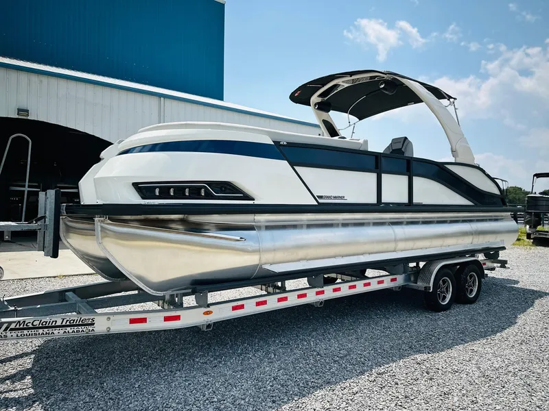Slide: The Image of 2025 Harris Grand Mariner 250 pontoon boat on trailer, parked outdoors. - 6