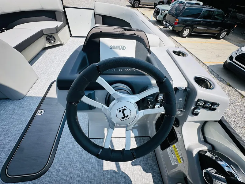 Slide: The Image of 2025 Harris Cruiser 230 boat steering wheel and dashboard, featuring modern controls and seating. - 11
